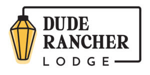 Dude Rancher Lodge logo with a yellow lantern graphic on the left and bold serif text inside a framed outline.